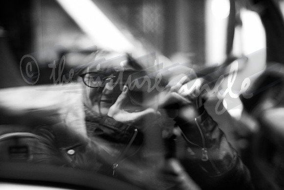 Self-portrait in a white van window